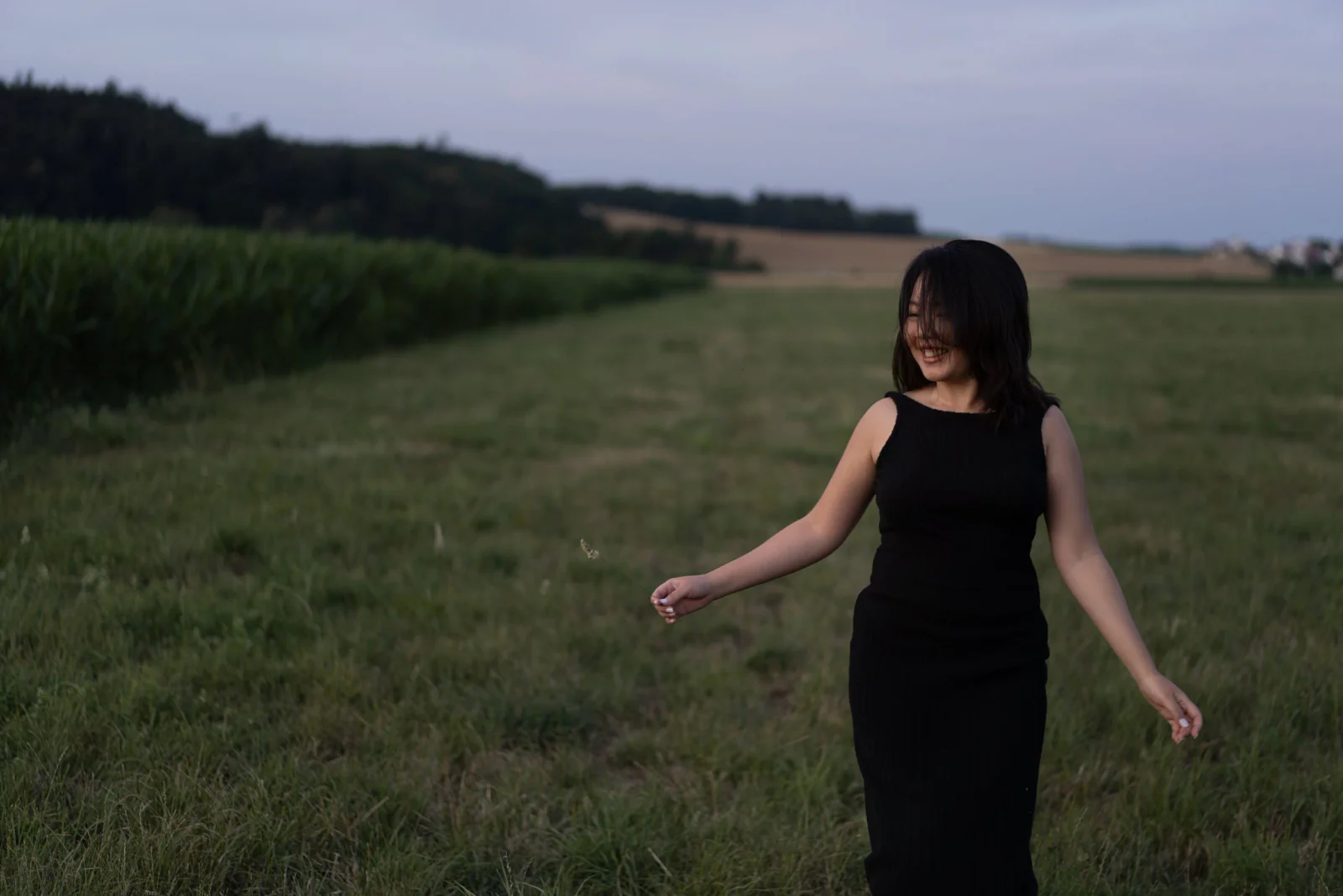 Bewegtes Portrait einer Frau in schwarzem Kleid auf einer Wiese