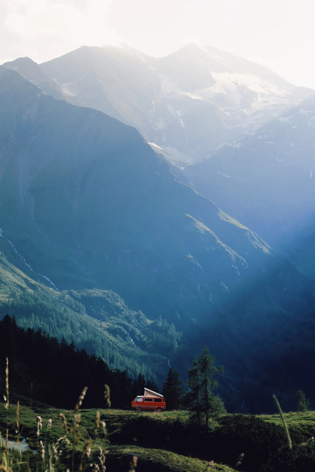 Rote Bergbahn in einer tiefen, lichtdurchfluteten Alpenlandschaft