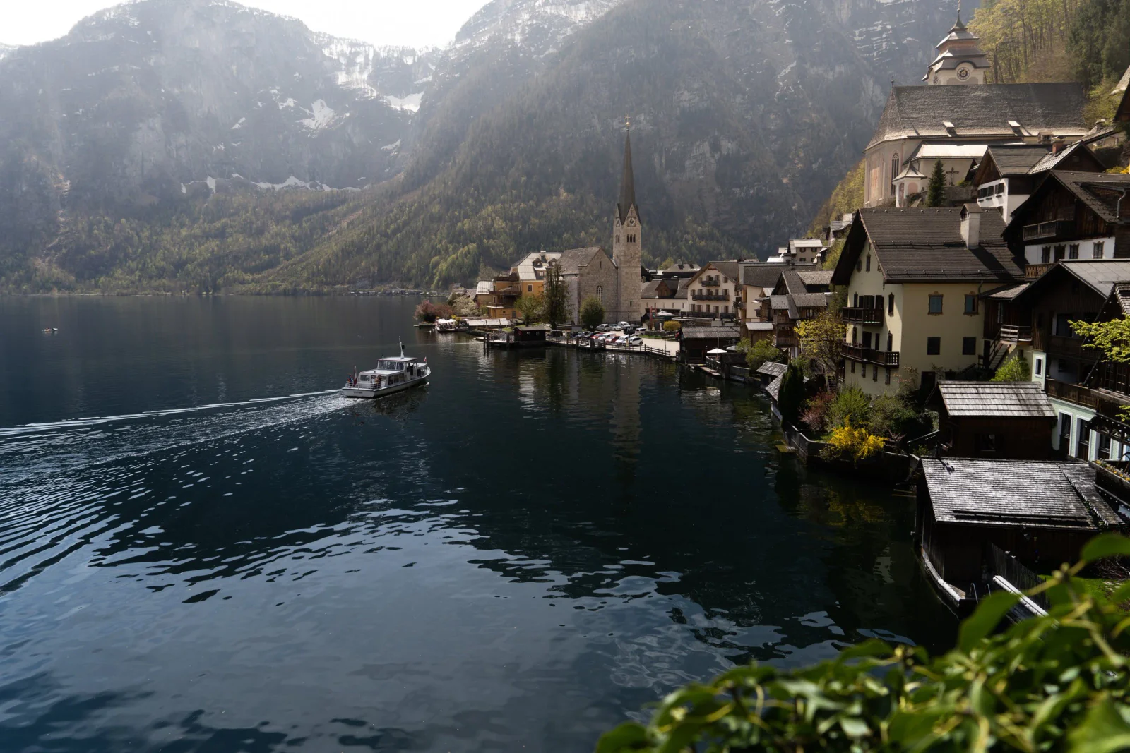 Historischer Ort am Bergsee mit Boot und steilen Berghängen