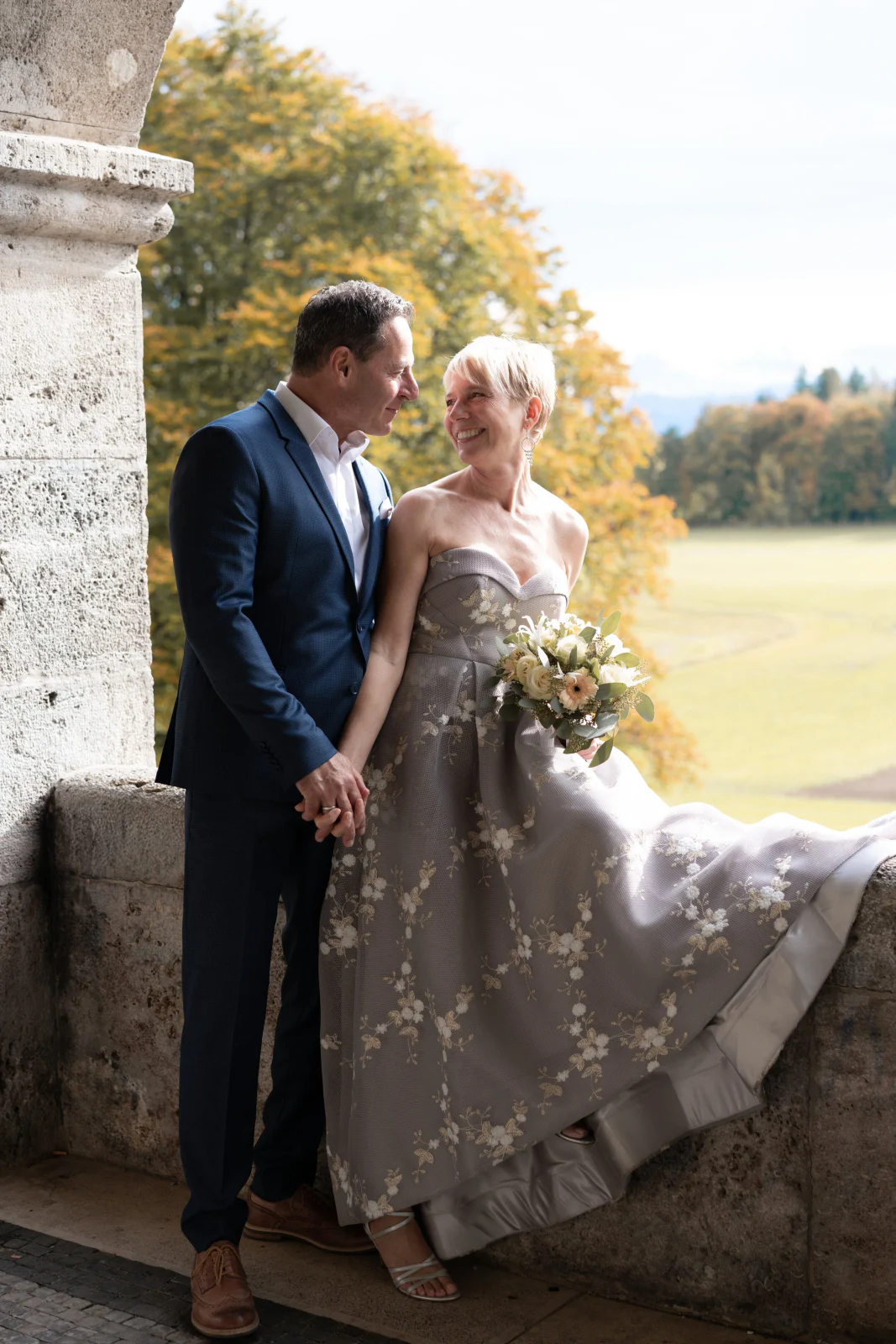 Brautpaar im herbstlichen Licht an einer historischen Arkade