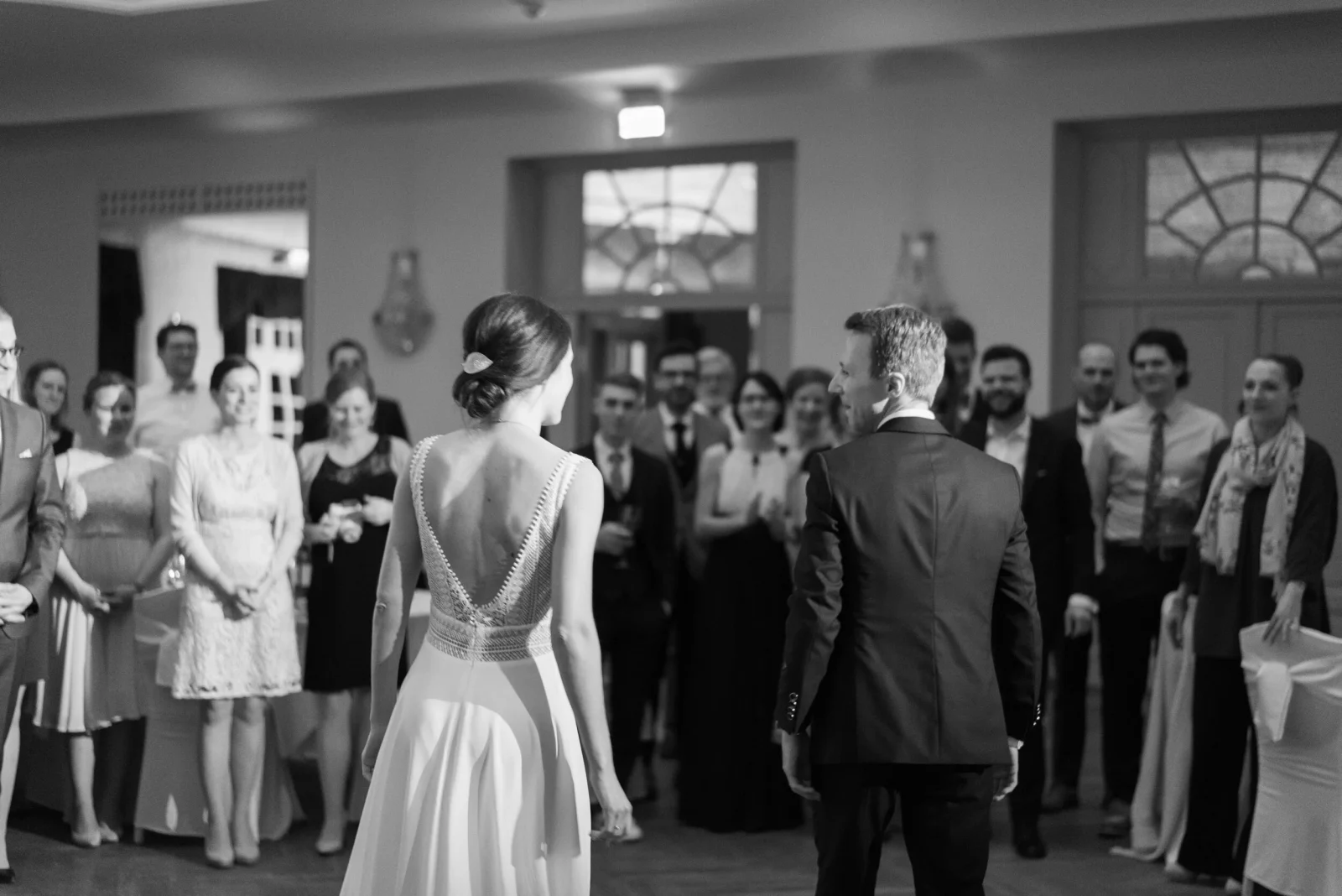 Brautpaar beim Hochzeitstanz mit seinen Gästen in Schwarz-Weiß