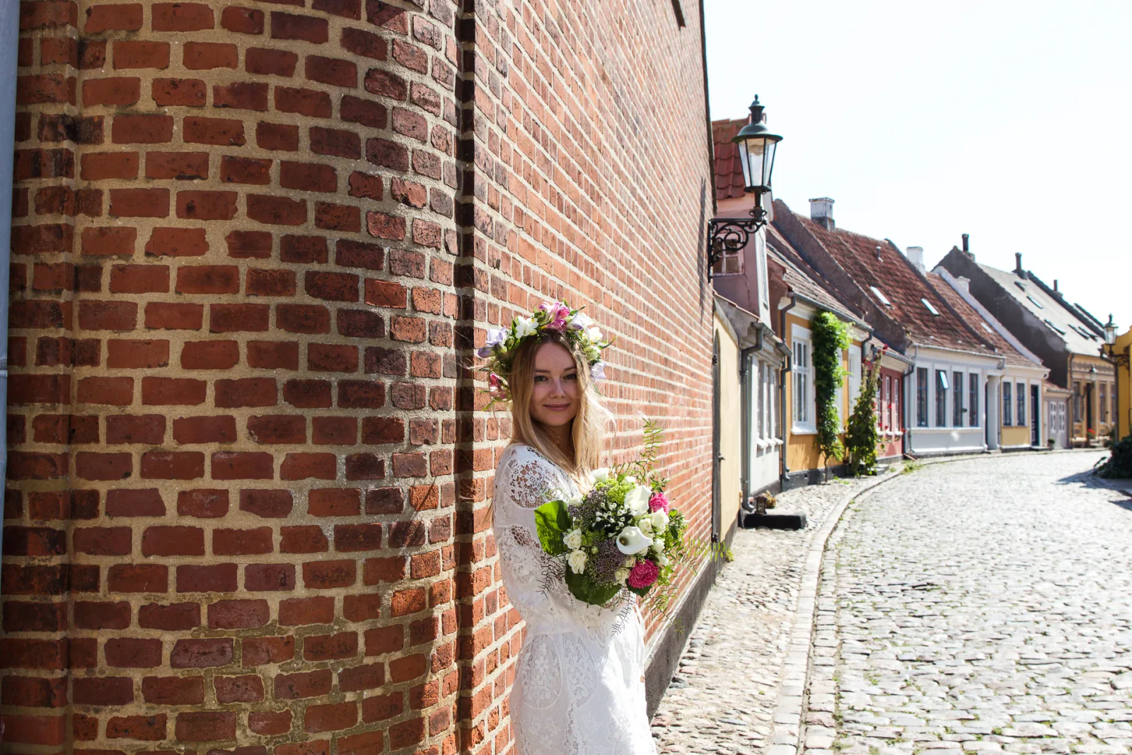 Braut mit Blumenkranz und Brautstrauß in einer historischen Altstadt