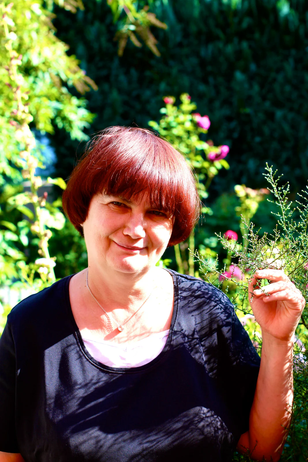 Natürliches Portrait einer Frau mit Blume im Garten